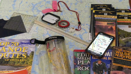 Collection of outdoor gear and books on a map